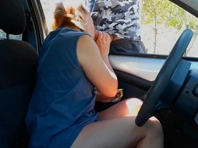A stranger receives a blowjob from a blonde in a parking lot
